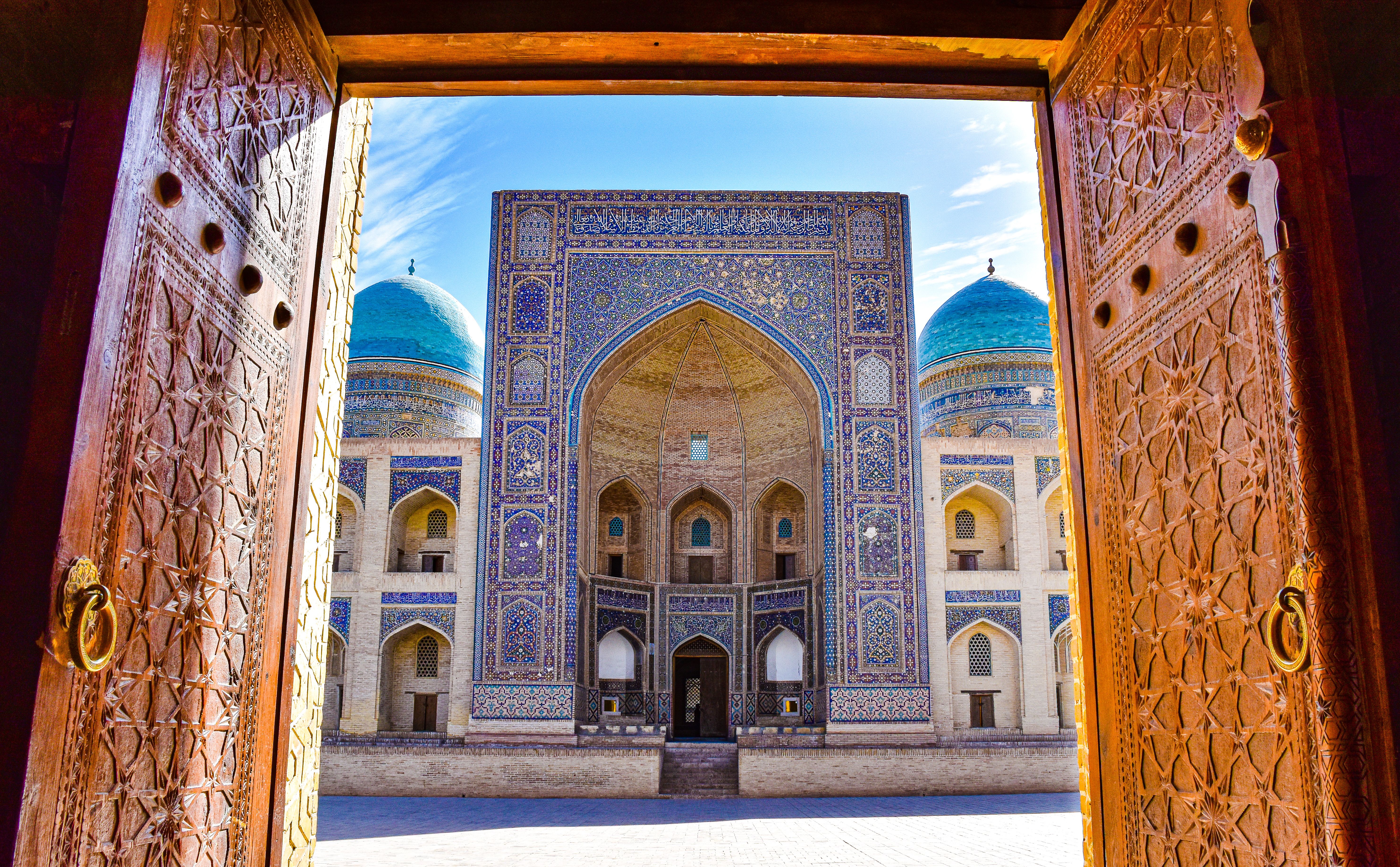 Historic building viewed through carved wooden doors